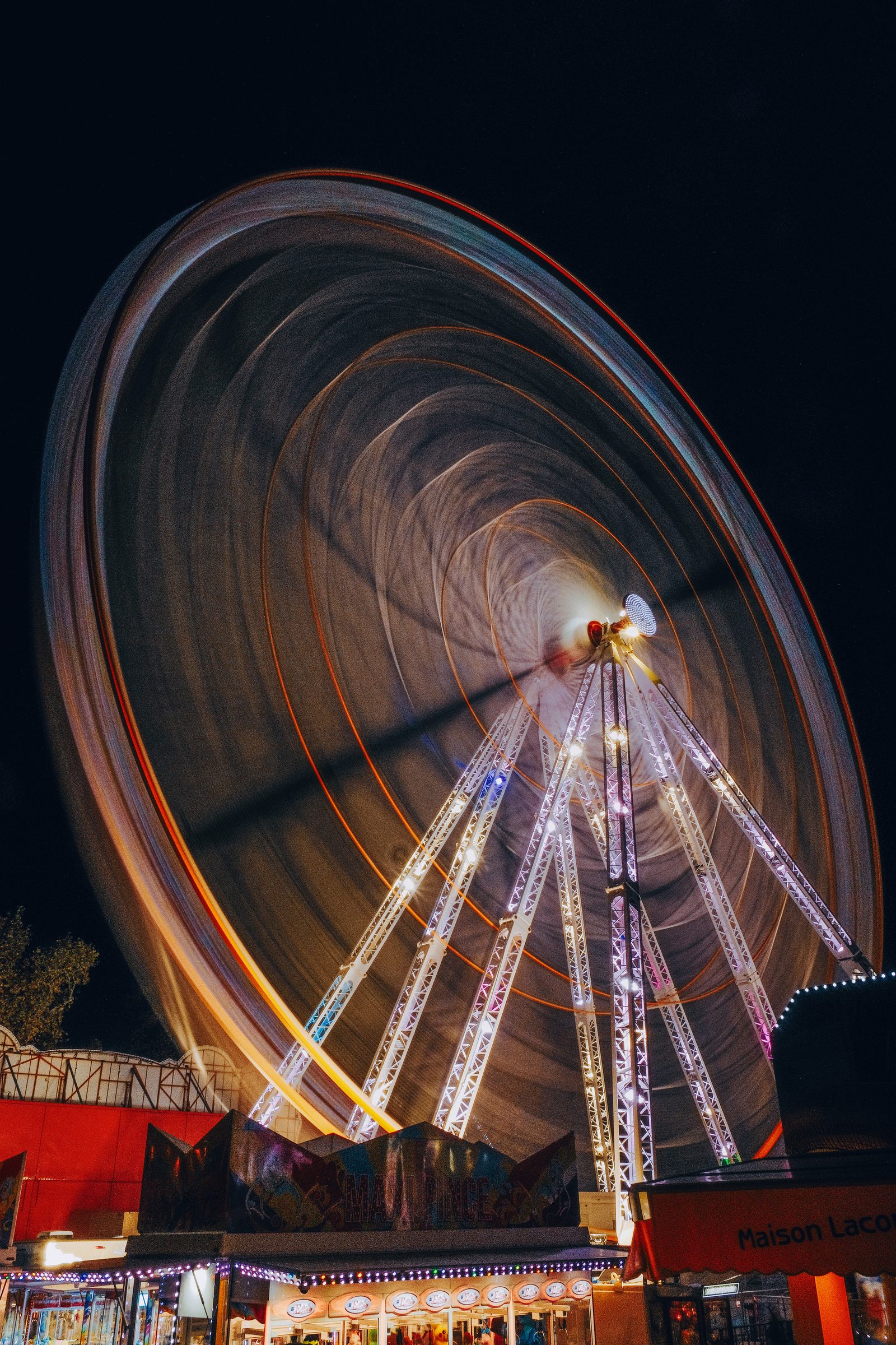 Les traînées lumineuses d’une grande roue au-dessus des stands